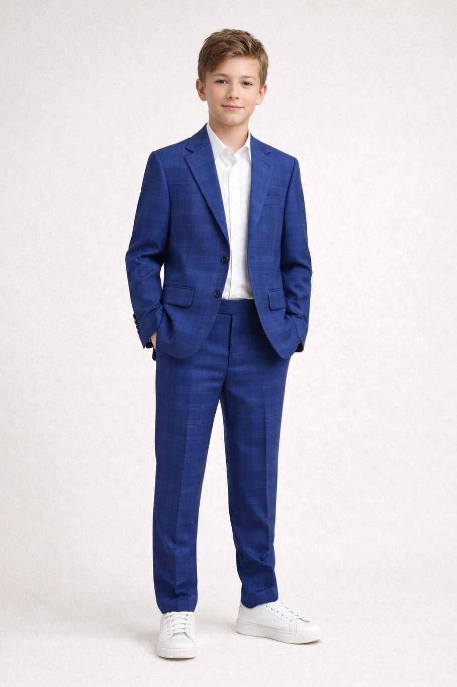Young boy wearing a blue suit with a white shirt on a white background
