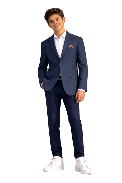 Young man wearing a navy suit with white shirt and white sneakers on a light gray background
