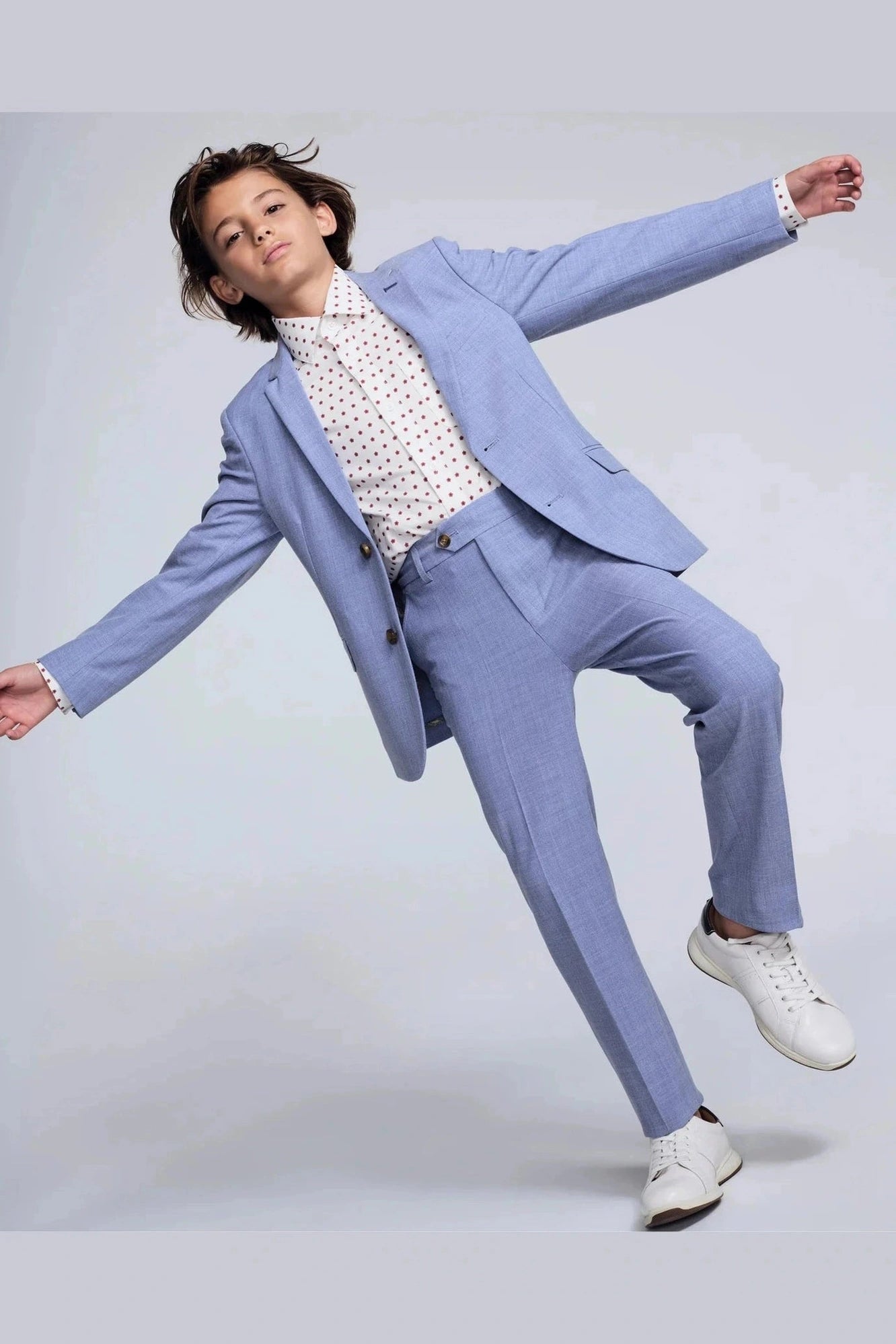 Person wearing a light blue suit with a white shirt on a plain background