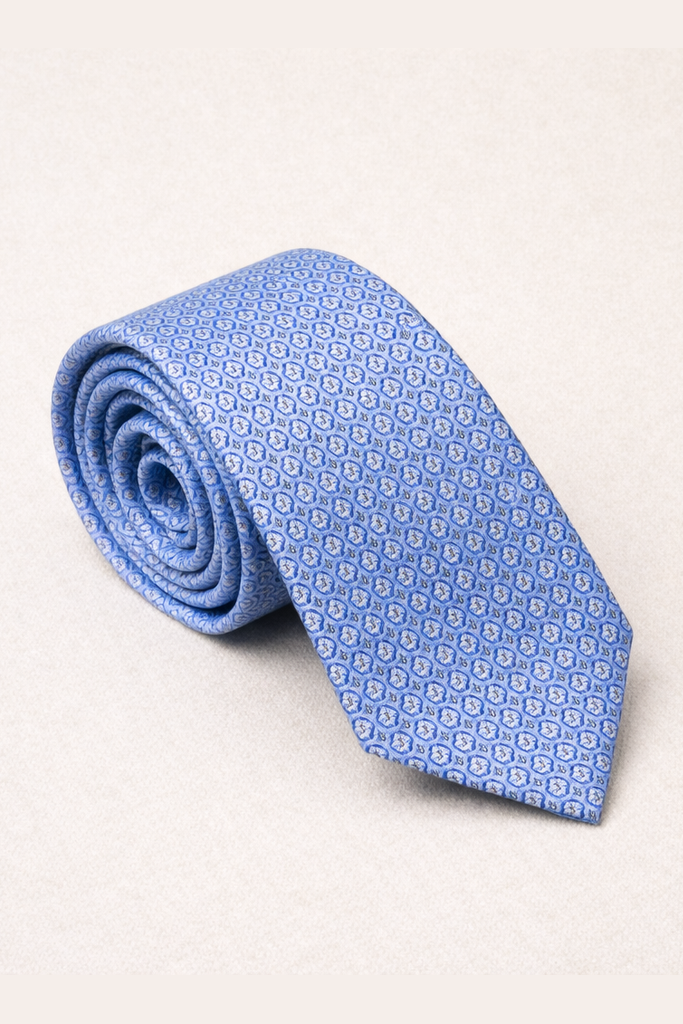 Rolled-up blue patterned tie on a light gray background
