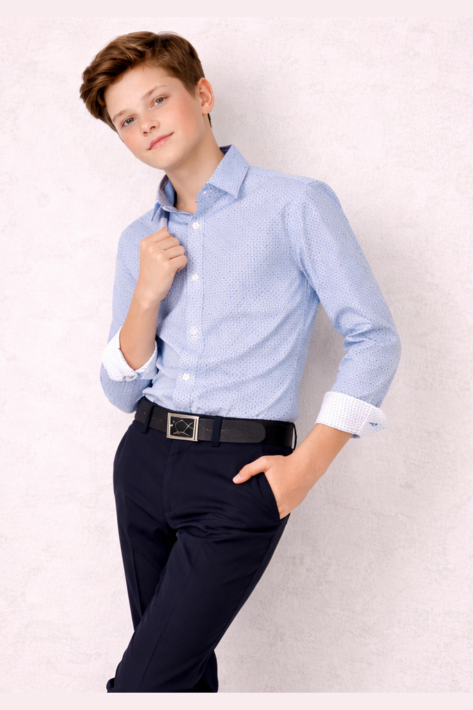 Young person wearing a light blue checkered shirt and dark pants against a plain background