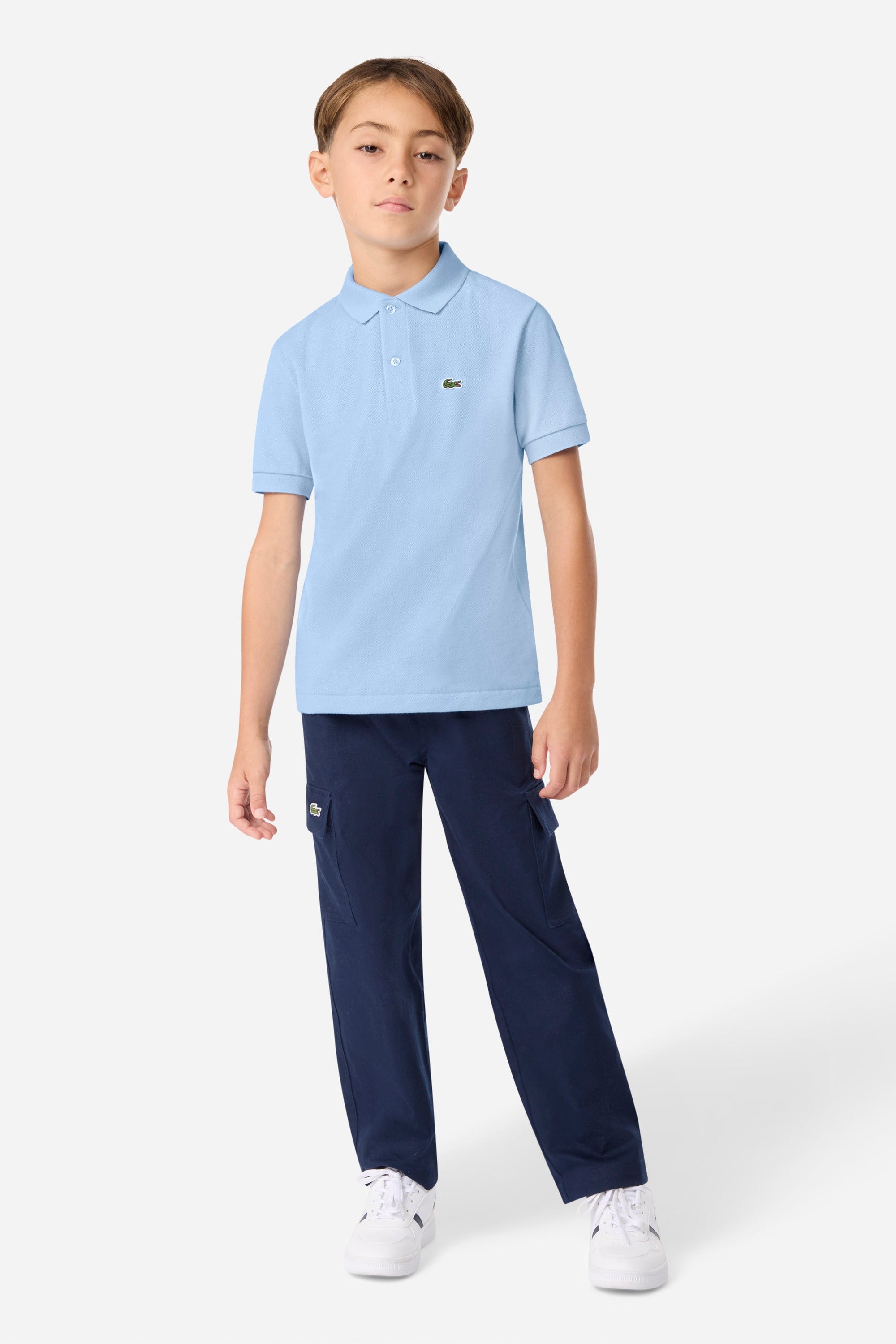 Child wearing a light blue polo shirt and navy pants on a white background