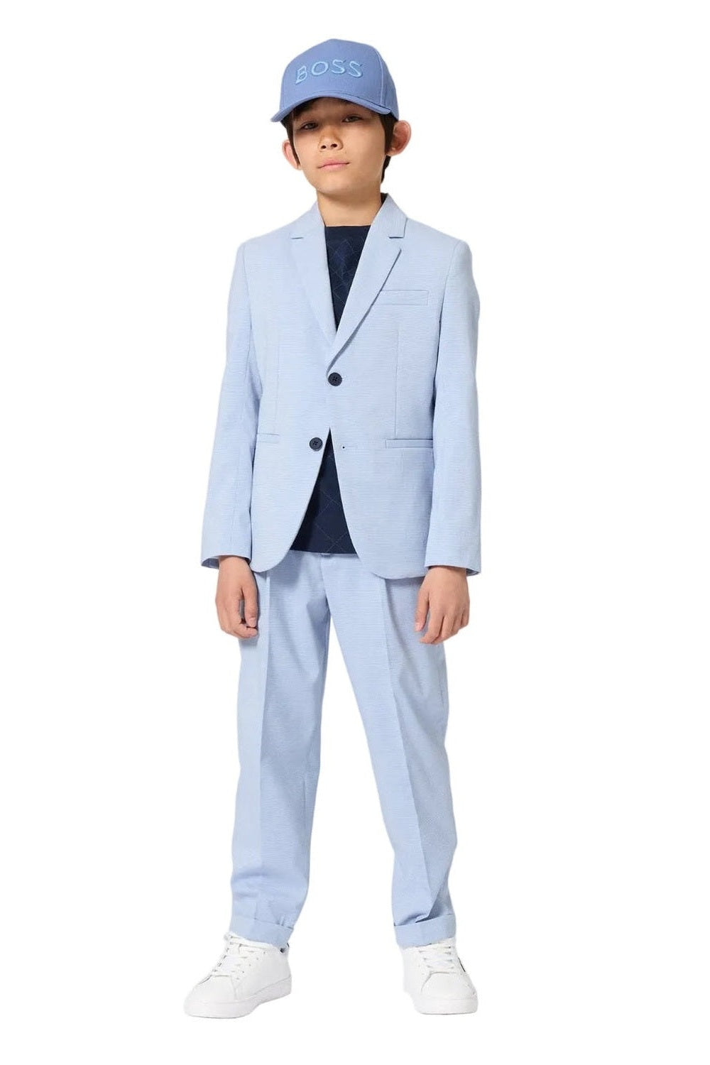 Child wearing a light blue suit and cap on a white background