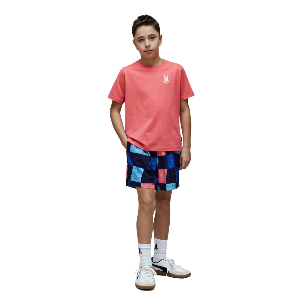 Person wearing a red t-shirt and colorful checkered shorts on a white background
