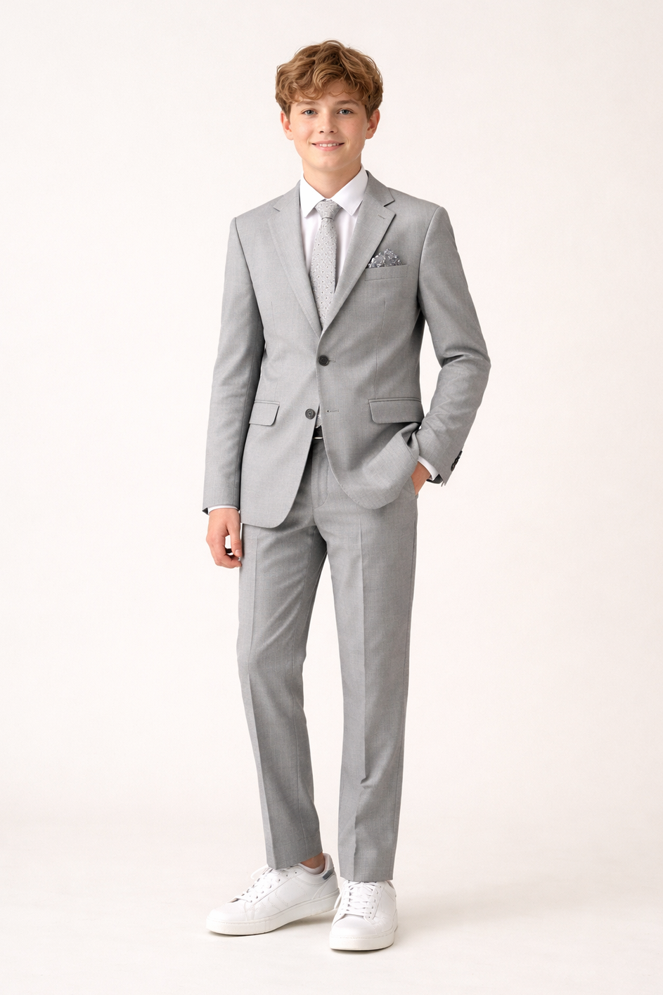 Young boy wearing a gray suit with a white shirt on a white background