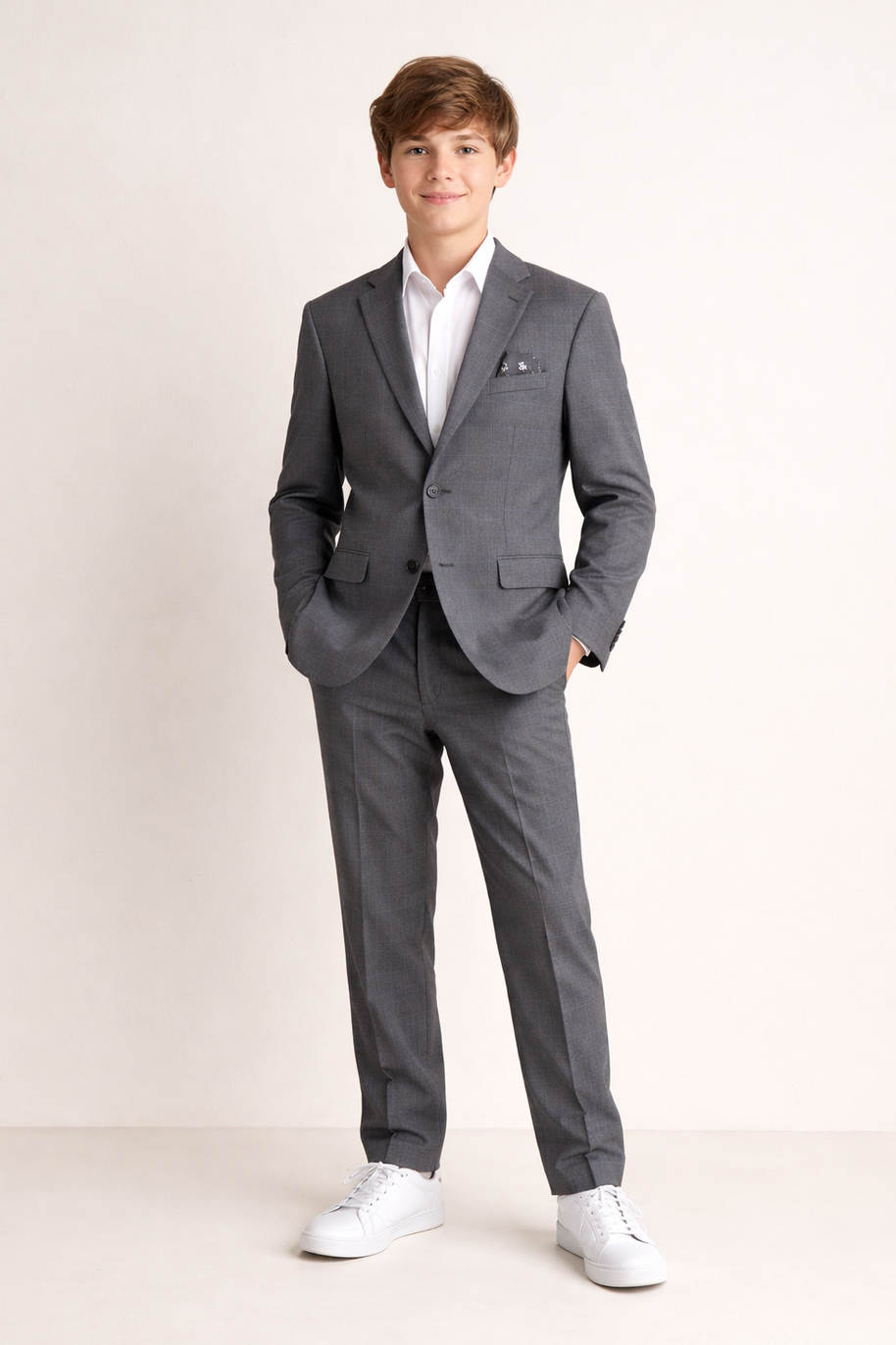 Person wearing a gray suit with a white shirt on a plain background
