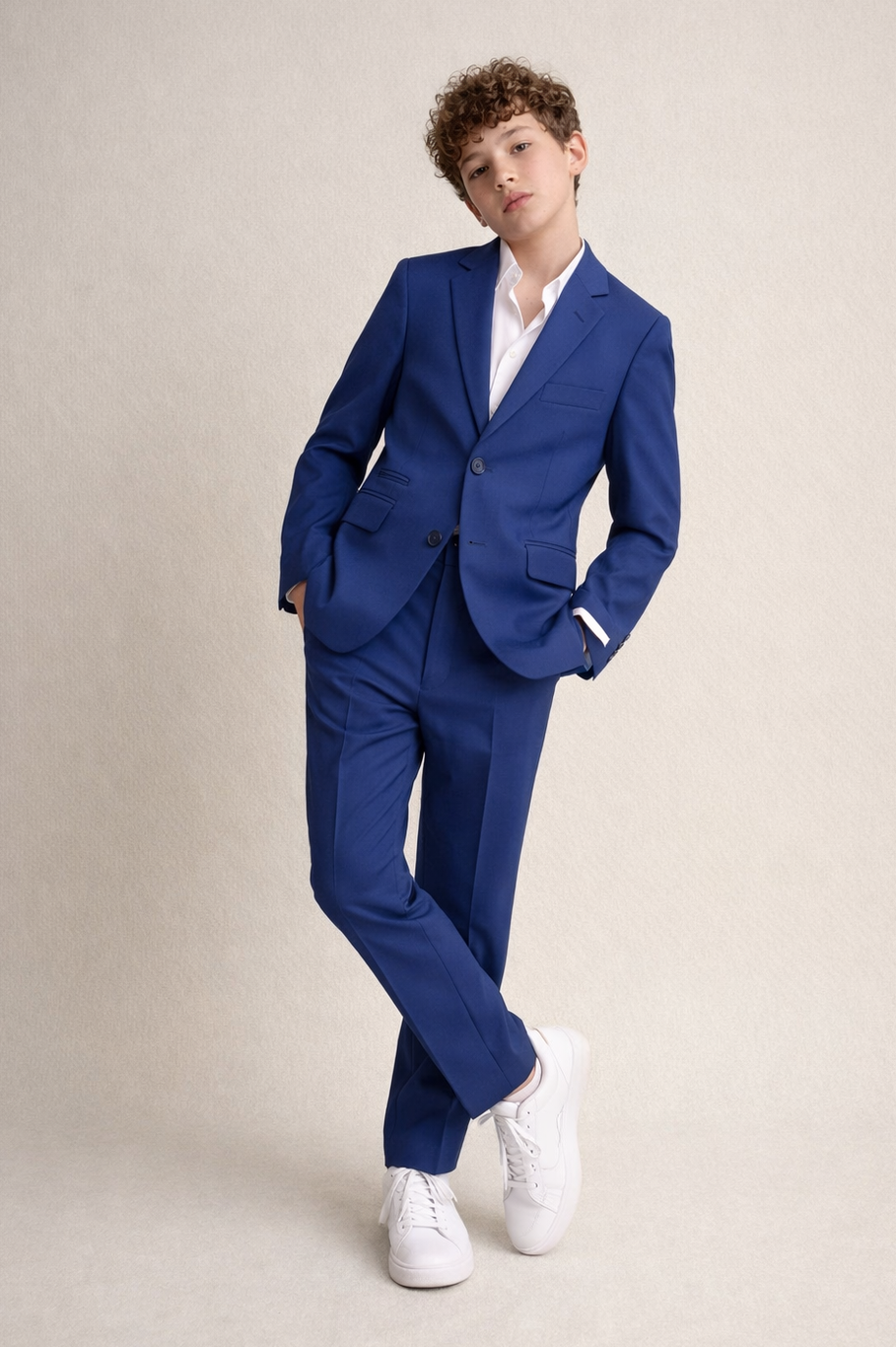 Person wearing a blue suit with white shoes on a beige background