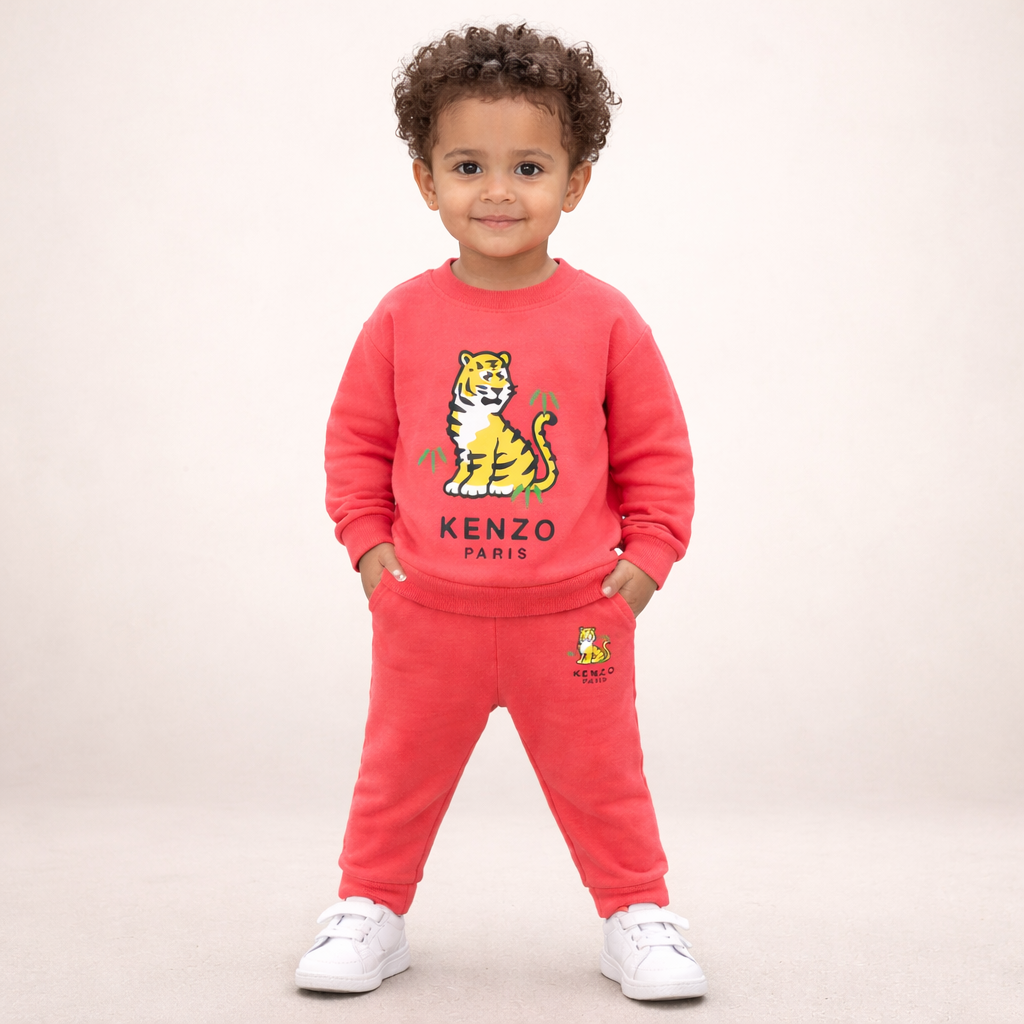 Child wearing a red Kenzo outfit with a tiger design on a beige background