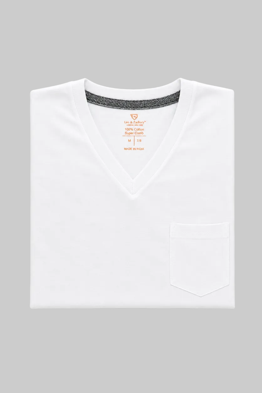 A folded white V-neck scrub top with a chest pocket, shown on a light gray background. The inside collar reveals a gray textured lining and orange printed text including 'Maid & Mercy'.
