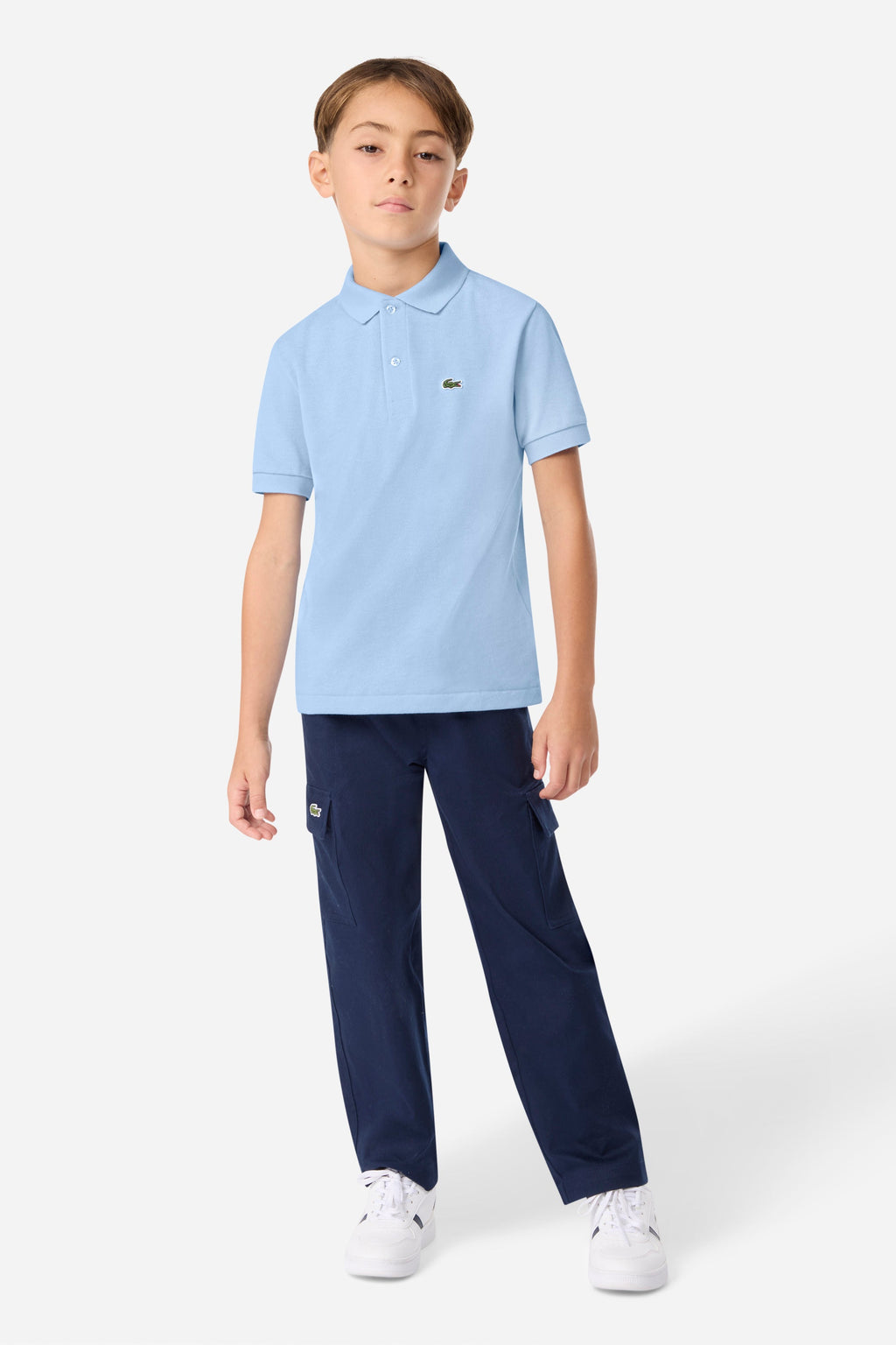 Child wearing a light blue polo shirt and navy pants on a white background